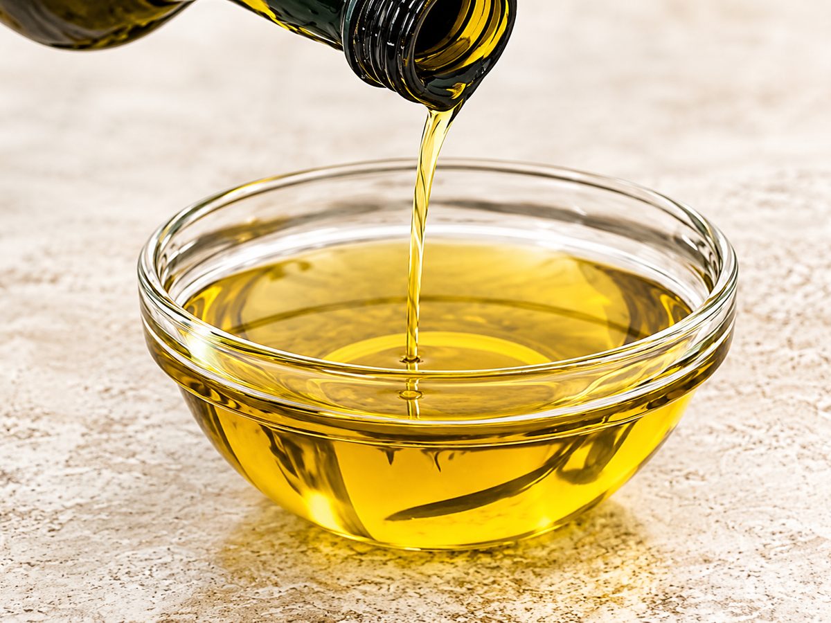 Edible oil being poured into a glass bowl
